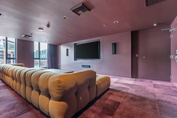 Community theater room with velvet sectional and screen